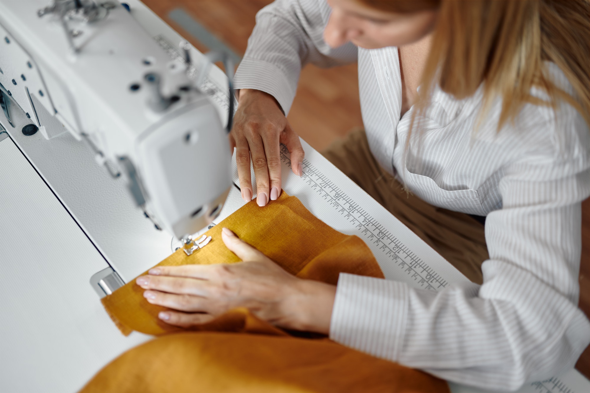 Seamstress works on sewing machine at workplace